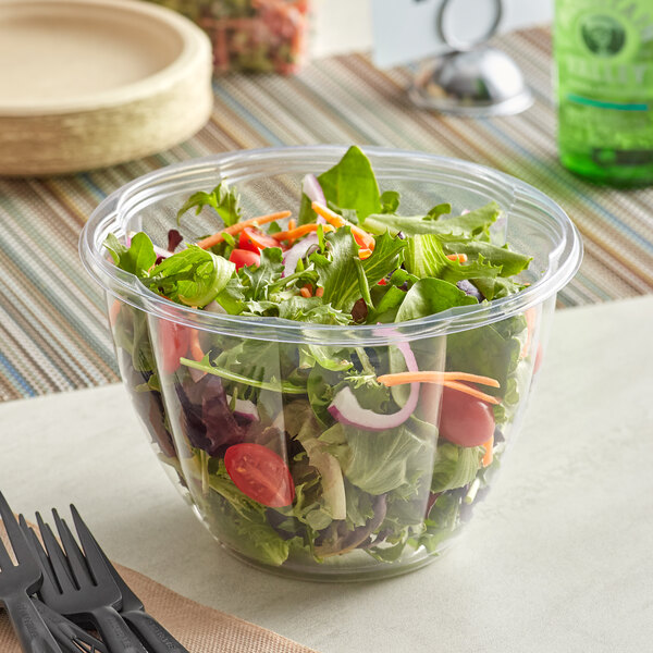 A salad in a clear plastic bowl.