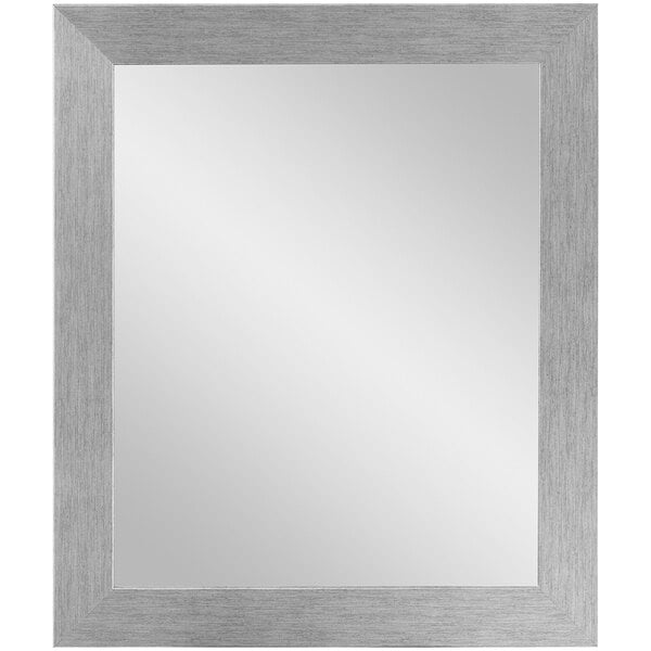 A BrandtWorks silver framed mirror hanging on a white wall.