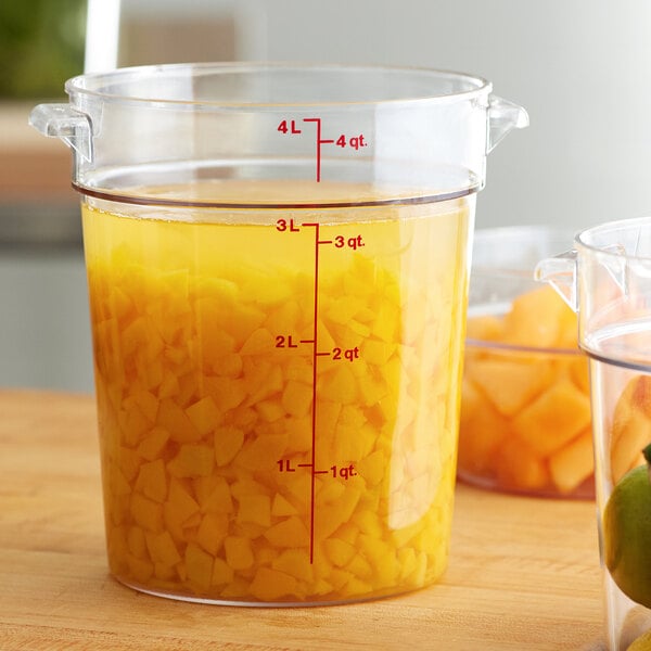 A large clear Cambro food storage container full of diced pineapples.