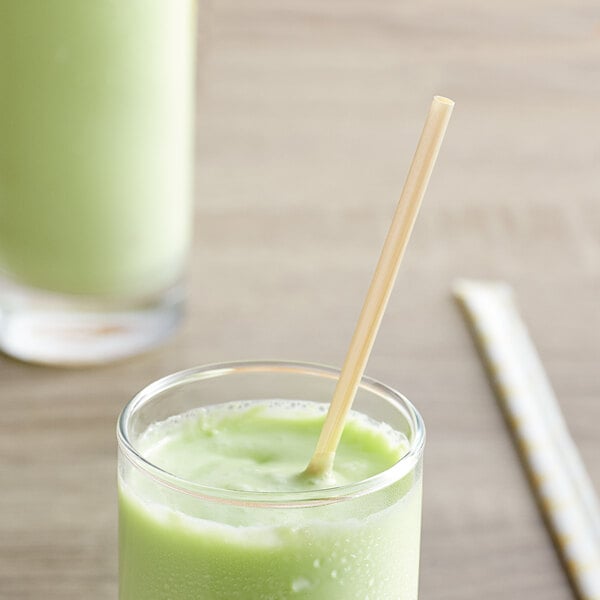 A glass of green smoothie with a HAY! wheat straw in it.