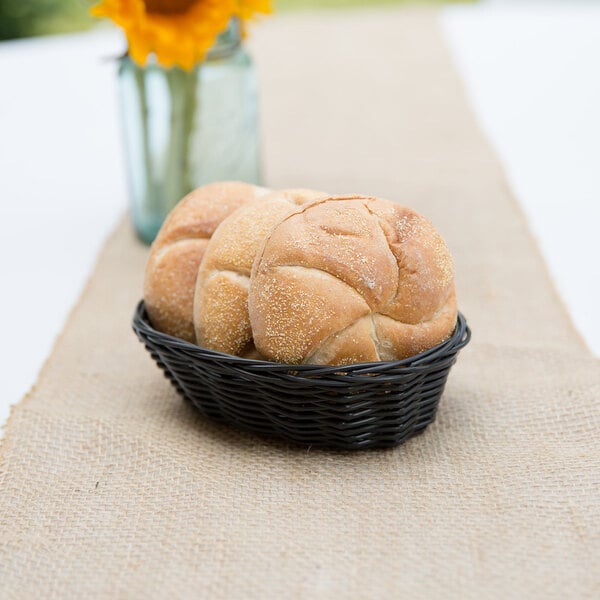 An oval black rattan basket filled with bread.