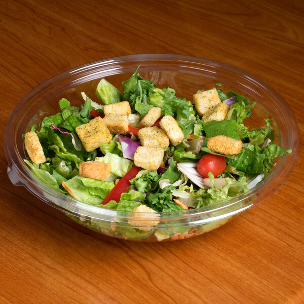 A Sabert clear plastic bowl filled with salad.