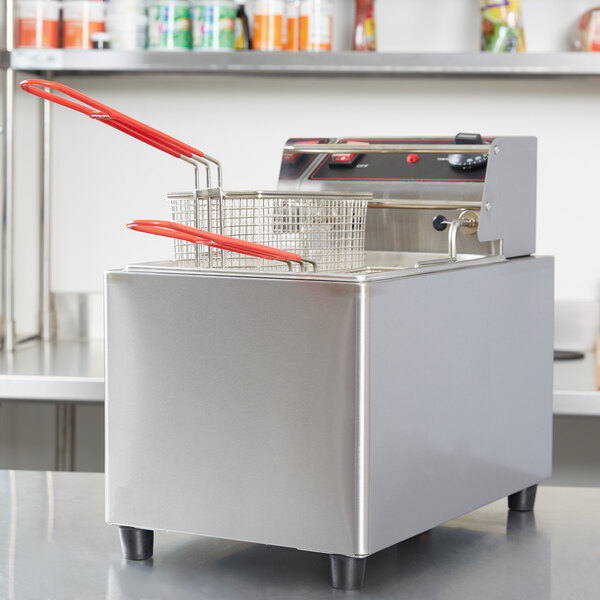A Cecilware stainless steel electric countertop deep fryer with red handles on top and a basket inside.
