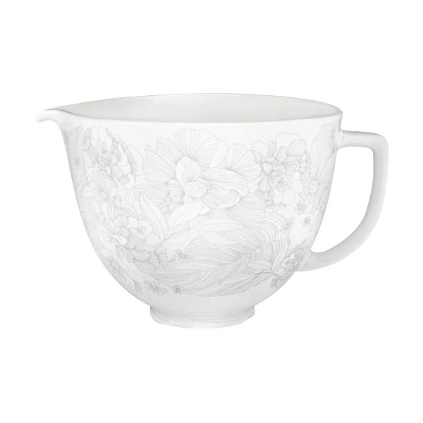 A white ceramic mixing bowl with a floral design and handle.