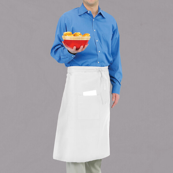 A man wearing a white Chef Revival bistro apron holding a bowl of food.