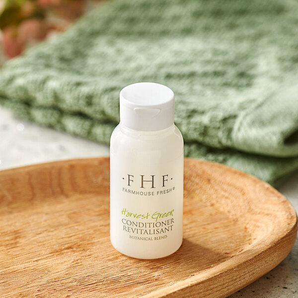 A white FarmHouse Fresh bottle of conditioner on a wooden plate.