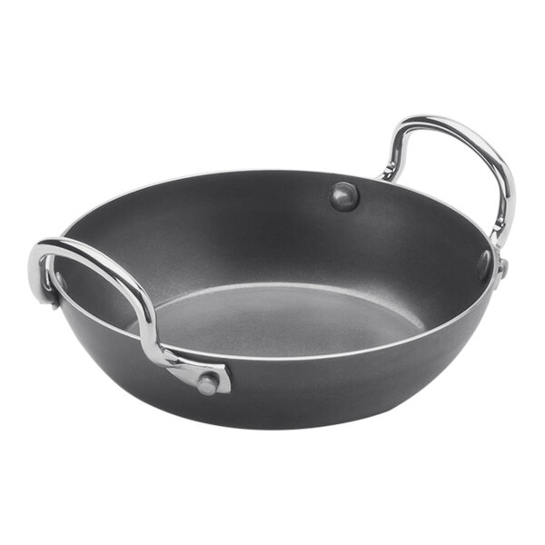 A black American Metalcraft carbon steel paella pan with silver handles.