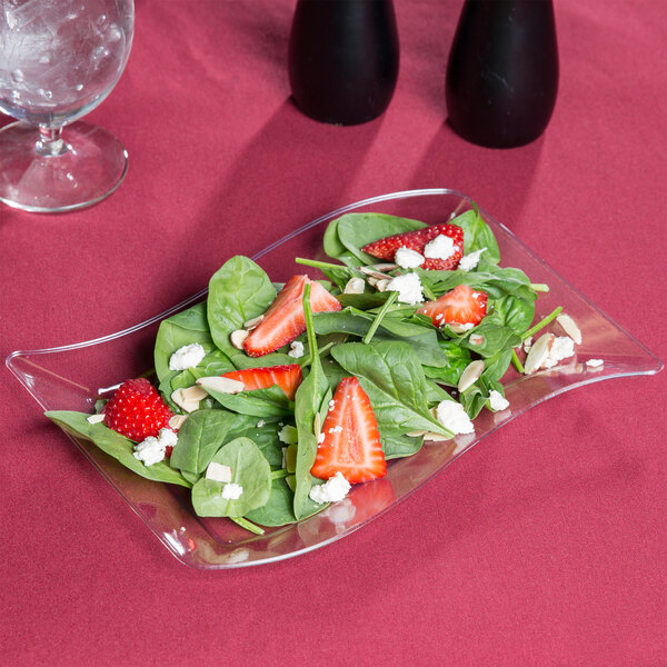 A salad with strawberries and spinach on a Fineline clear plastic salad plate.
