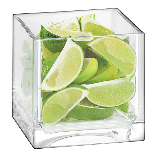 A clear Cal-Mil cube jar filled with lime slices.