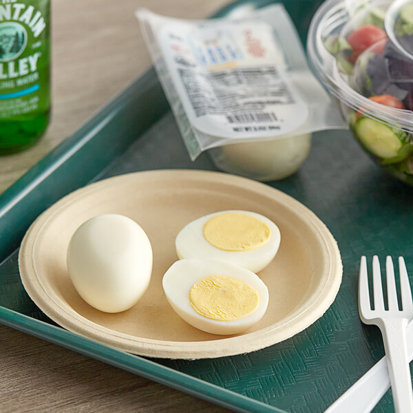 A tray with a plate of Easy Eggs Organic Peeled hard boiled eggs and salad.