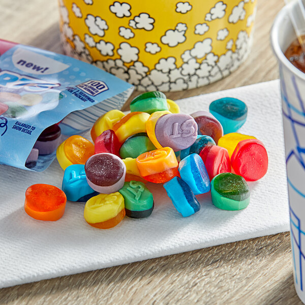 A group of SweeTarts Fruity Splitz Gummies on a napkin next to a cup of coffee.