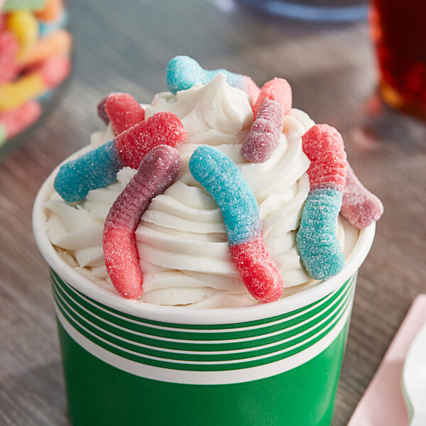 A white cup of ice cream with Trolli Very Berry Sour Brite Gummy Crawlers on top.