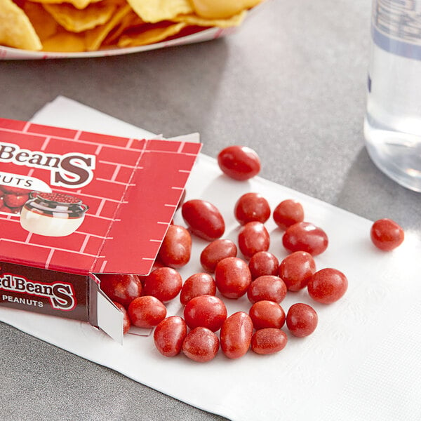 A Boston Baked Beans Original Candy box next to a bowl of chips.