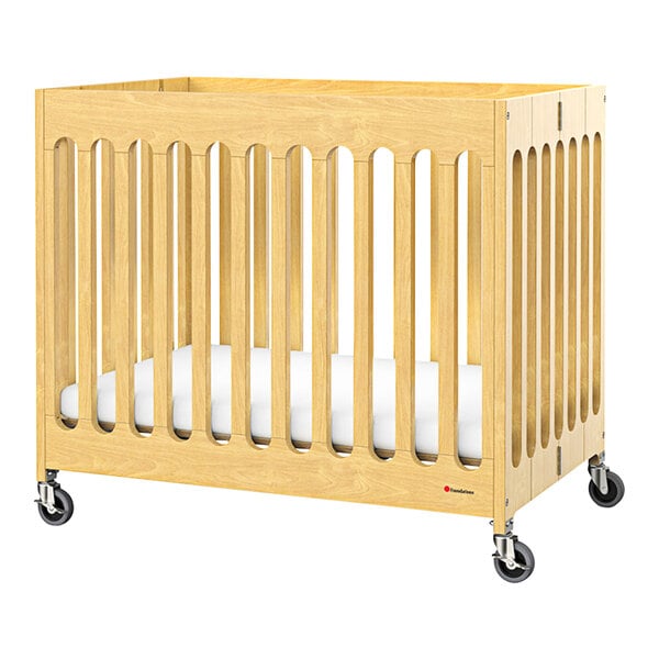 A Foundations Boutique wooden folding crib with wheels.