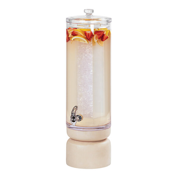 A Cal-Mil round beverage dispenser with a white-washed pine wood base filled with water with orange slices and lemons.
