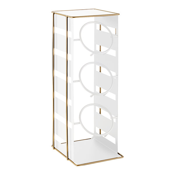 A white metal rack with three gold metal rings.
