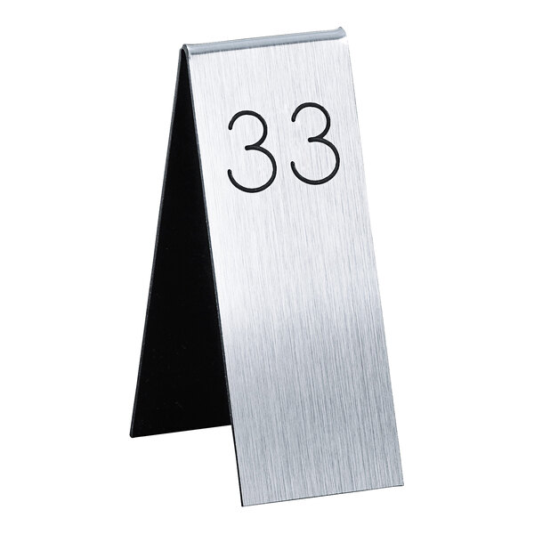 A silver metal Cal-Mil table number with black number 33.