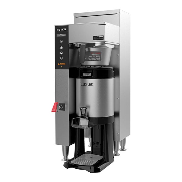 A Fetco commercial automatic coffee brewer with a silver and black metal container.