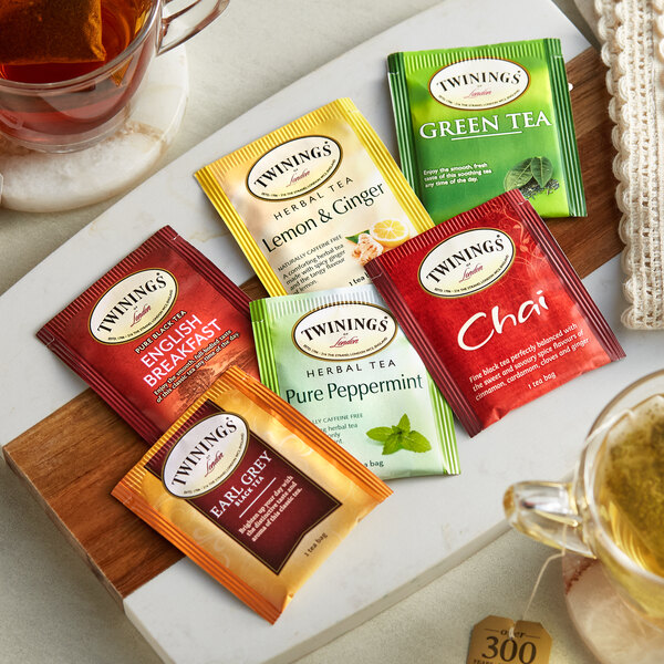 A green Twinings Tea Bag variety pack on a white background with a cup of tea.