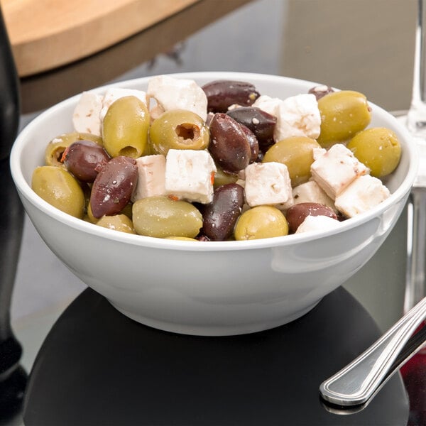 A white Siciliano bowl filled with olives and cheese.