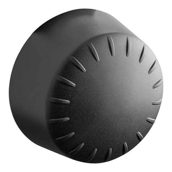 A black round knob with a circular pattern.