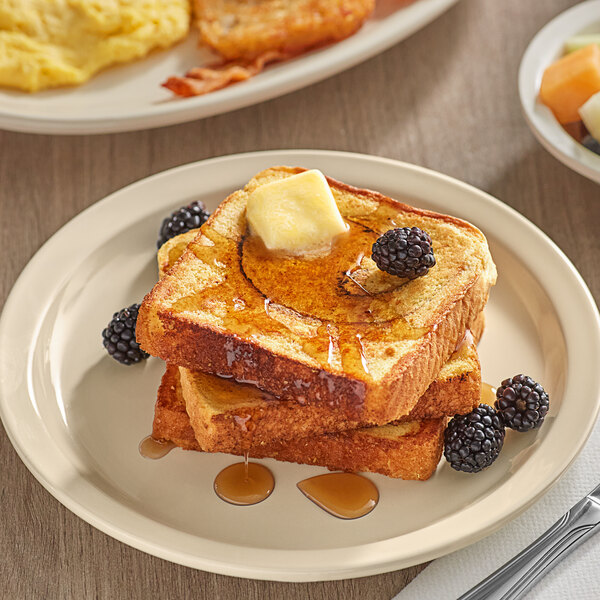 A stack of Krusteaz cinnamon swirl french toast with syrup and berries on a plate.
