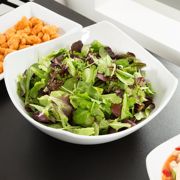 An American Metalcraft square stoneware bowl filled with salad on a table.