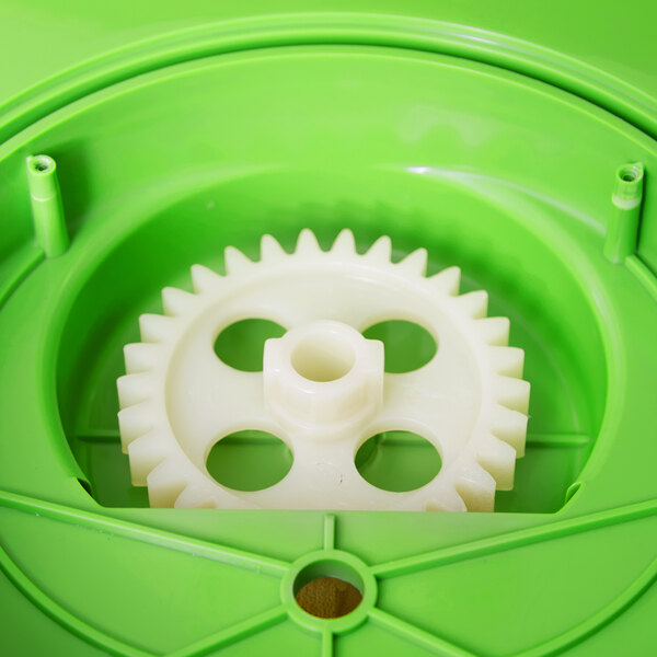 A white and yellow gear in a green plastic container with holes in it.