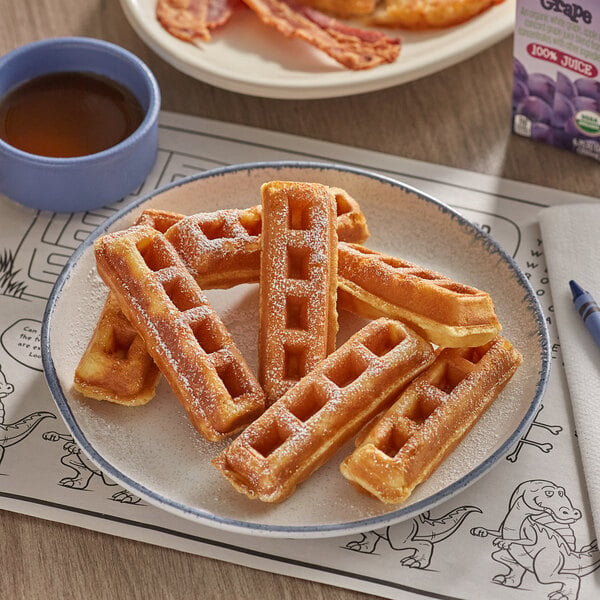 A plate of Krusteaz Belgian waffles with syrup on the table.