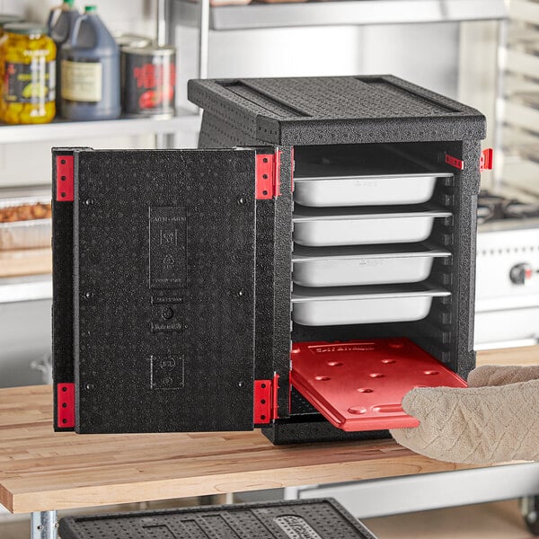 A black CaterGator front loading food pan carrier with white trays inside.