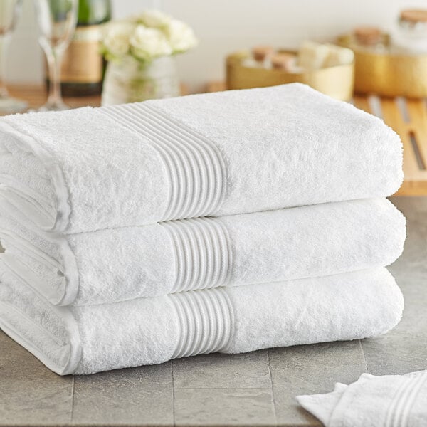 A stack of three white Lavex Luxury bath sheets.