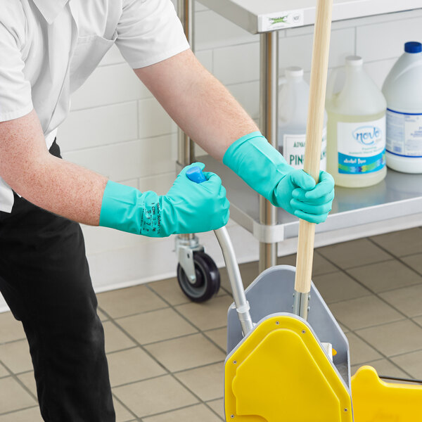 A person wearing Ansell AlphaTec Solvex dishwashing gloves and holding a mop.