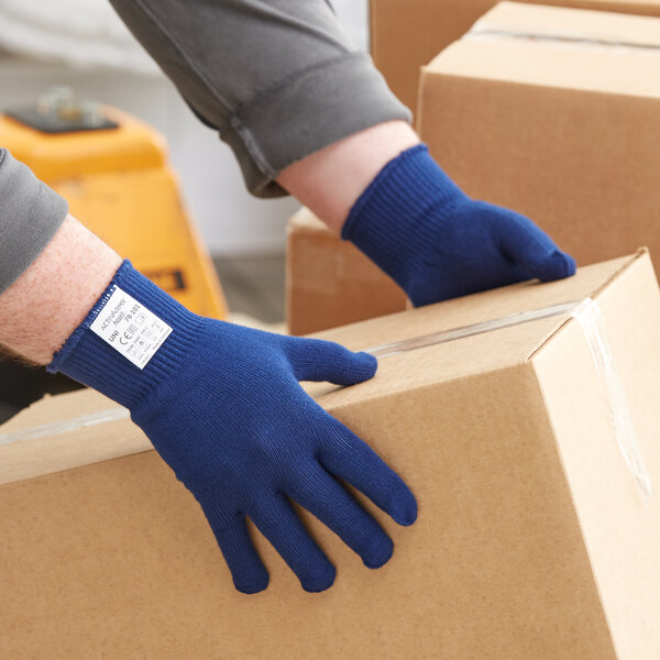 A person wearing Ansell ActivArmr light blue gloves holding a box.
