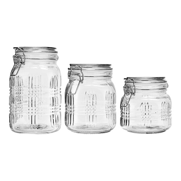 A group of three clear glass Stylesetter canisters with metal clasp lids.