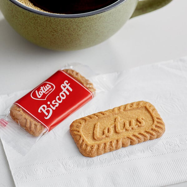 A Lotus Biscoff biscuit next to a cup of coffee.