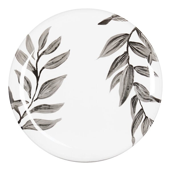 A white Cal-Mil melamine plate with black and white leaves painted on it.