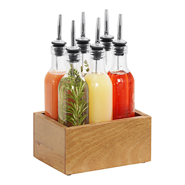 A Cal-Mil oak wood caddy with 6 glass flavoring syrup bottles inside.