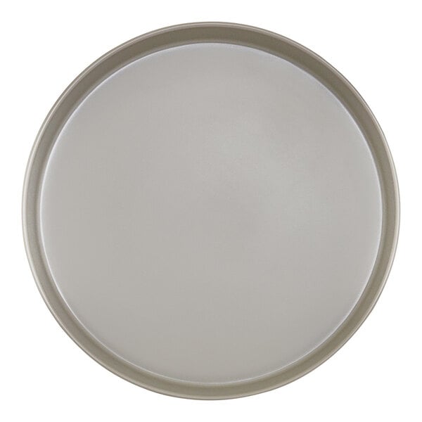 A close-up of a white Cal-Mil melamine plate with a raised rim and a white circle.