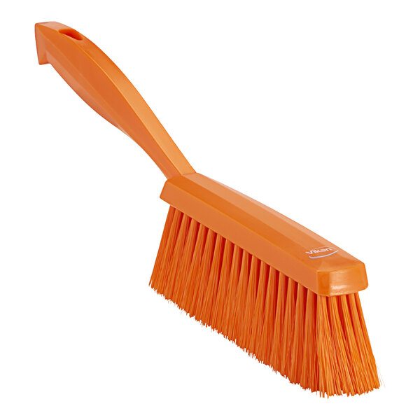 An orange hand brush with a handle.