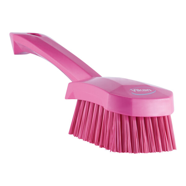 A Vikan pink washing brush with a handle.