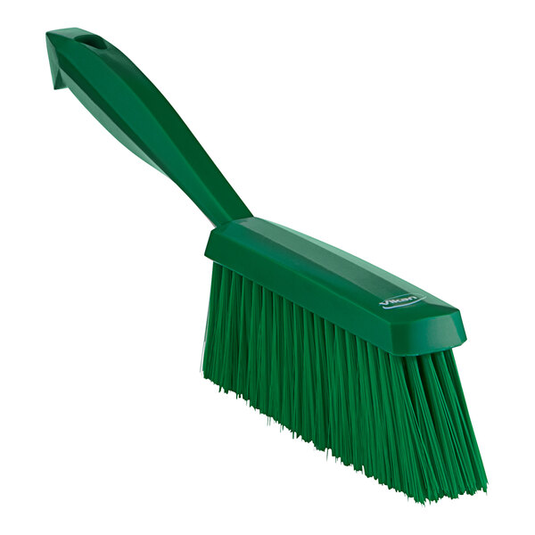 A green Vikan hand brush with a long handle.