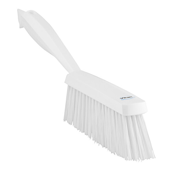 A close-up of a white Vikan hand brush with a handle and bristles.