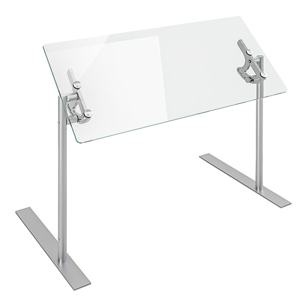 A Spring USA glass food shield on a glass table with metal legs.