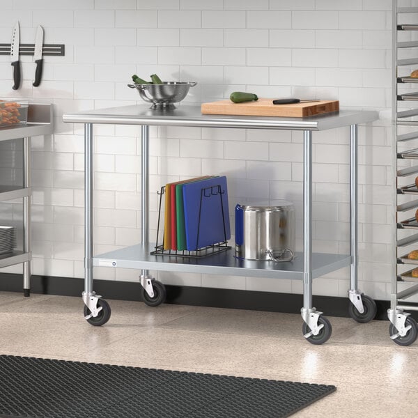 A Steelton stainless steel work table with an undershelf and casters holding a cutting board.