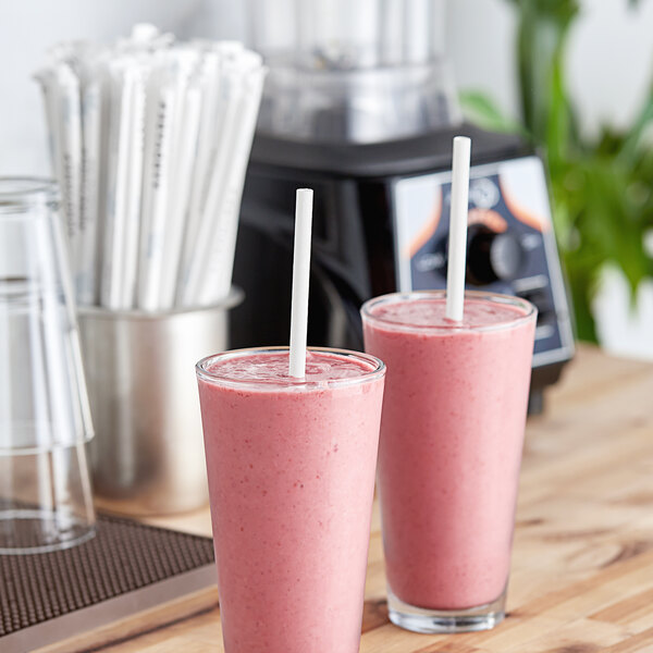 Two glasses of pink smoothies with Aardvark white wrapped paper straws.
