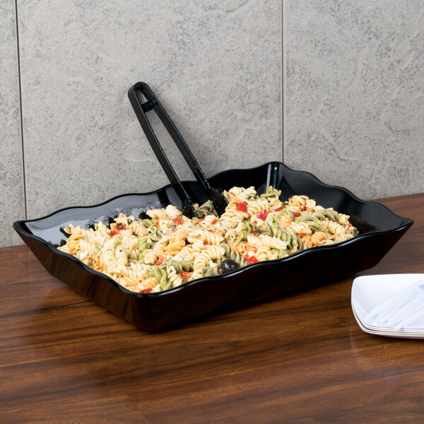 A black rectangular melamine tray with pasta on it.