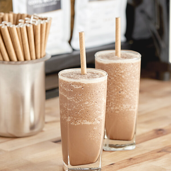 Two glasses of chocolate milkshakes with Aardvark giant brown straws.