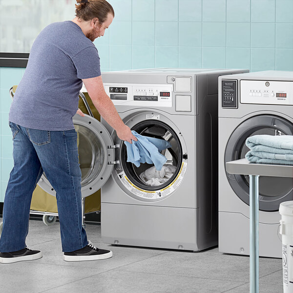 A man standing next to a Crossover front load washer.