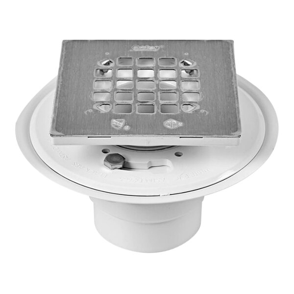 A white Oatey shower drain with a square brushed nickel metal grate.