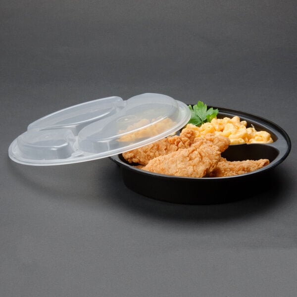 A black Pactiv plastic container with chicken and corn on it.